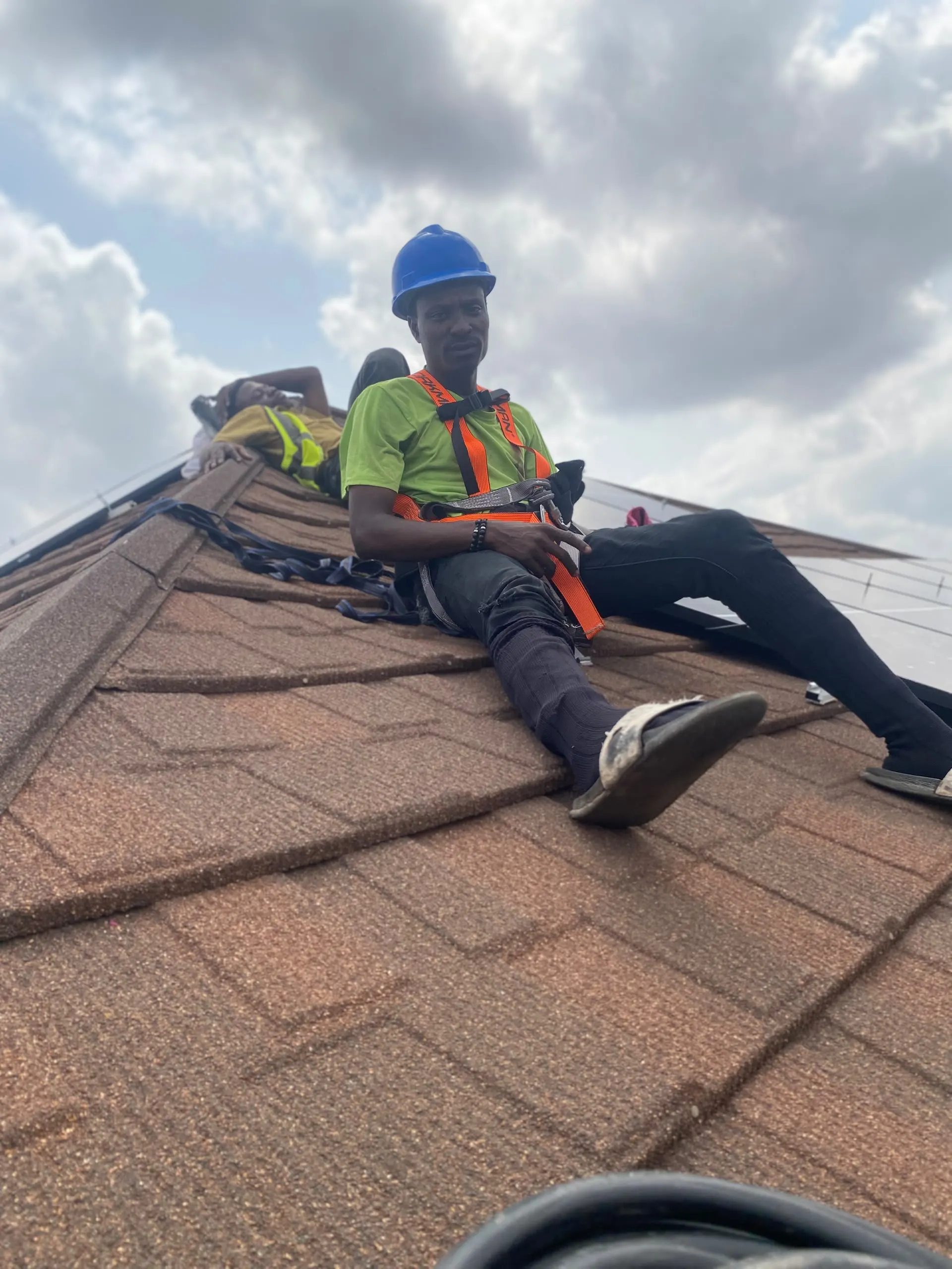 A fitter working on the roof in a safety harness and hi-vis vest.