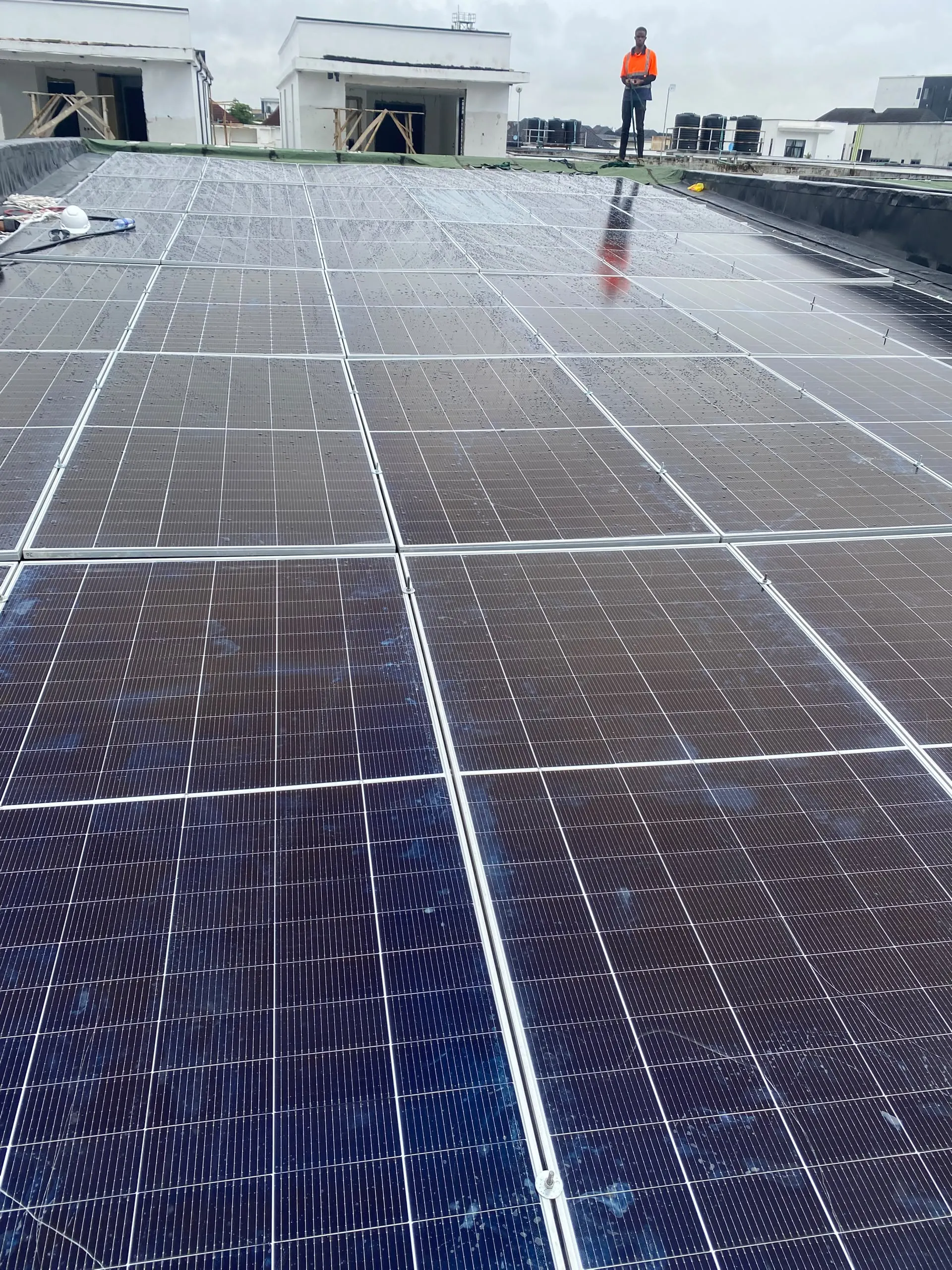 The completed array of bifacial solar panels laid across the full flat roof of the house.