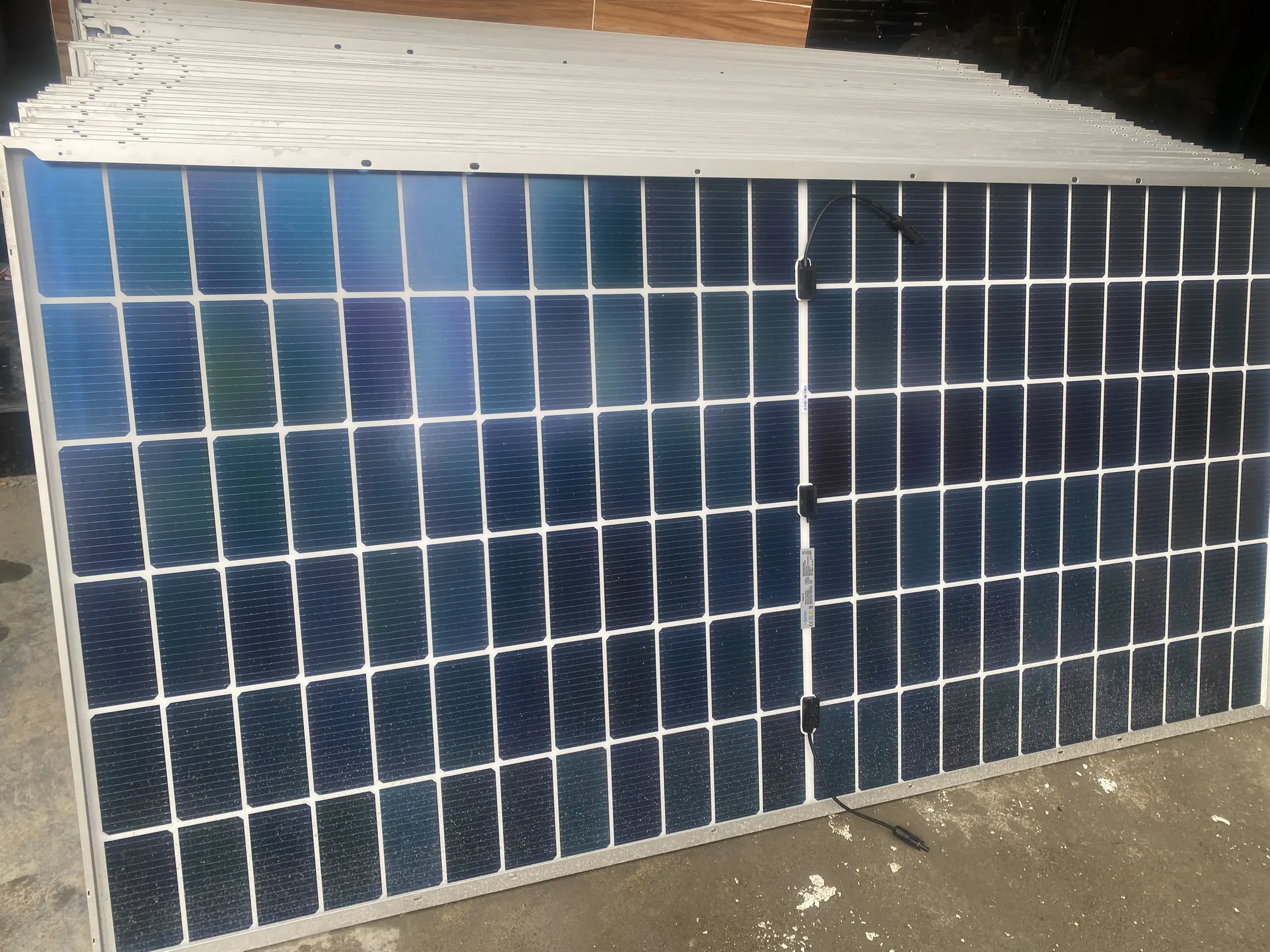 A pallet of bifacial solar panels delivered and unwrapped on site before installation.