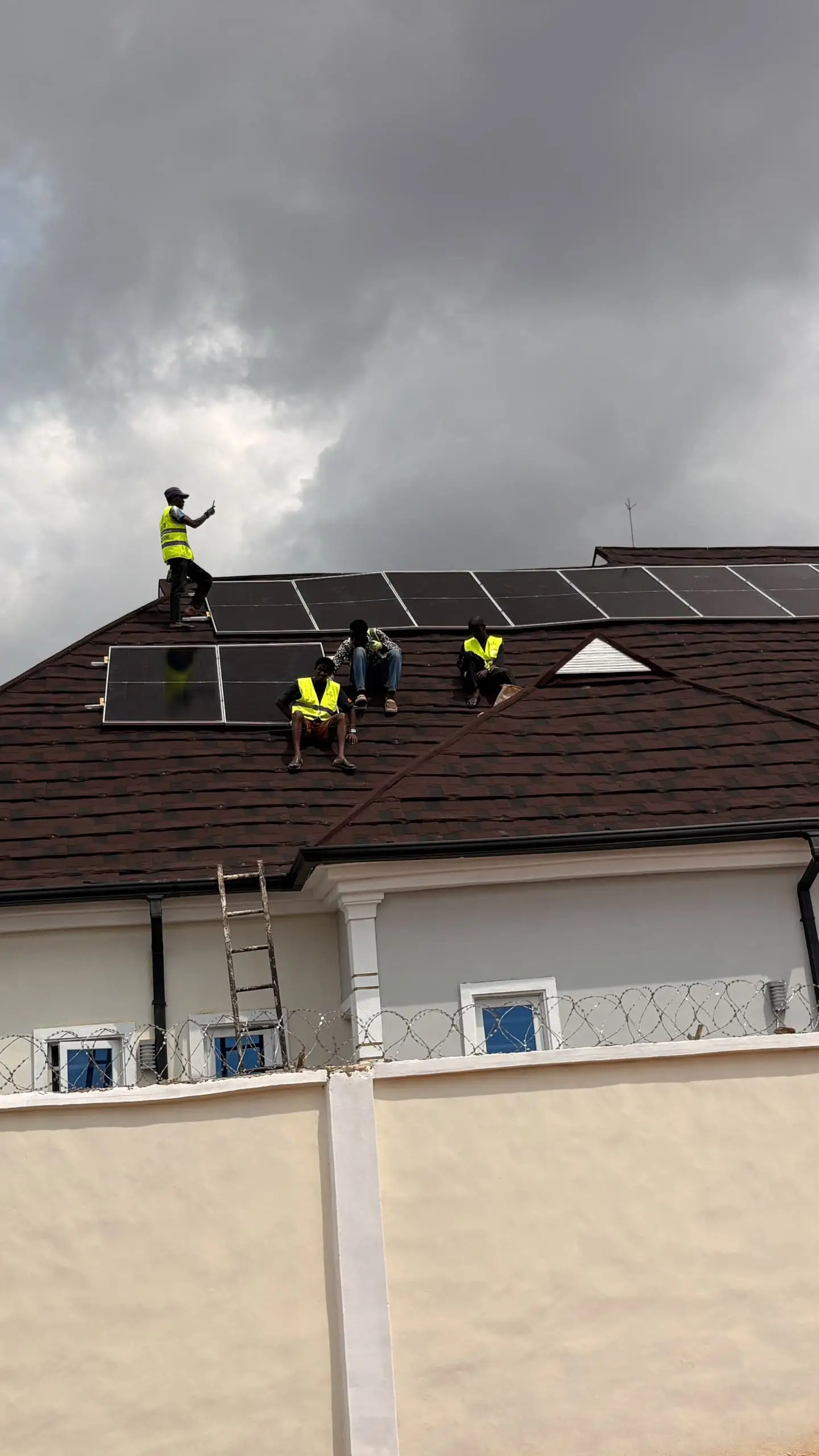 Fitters in hi-vis vests mounting solar panels on the hotel roof.