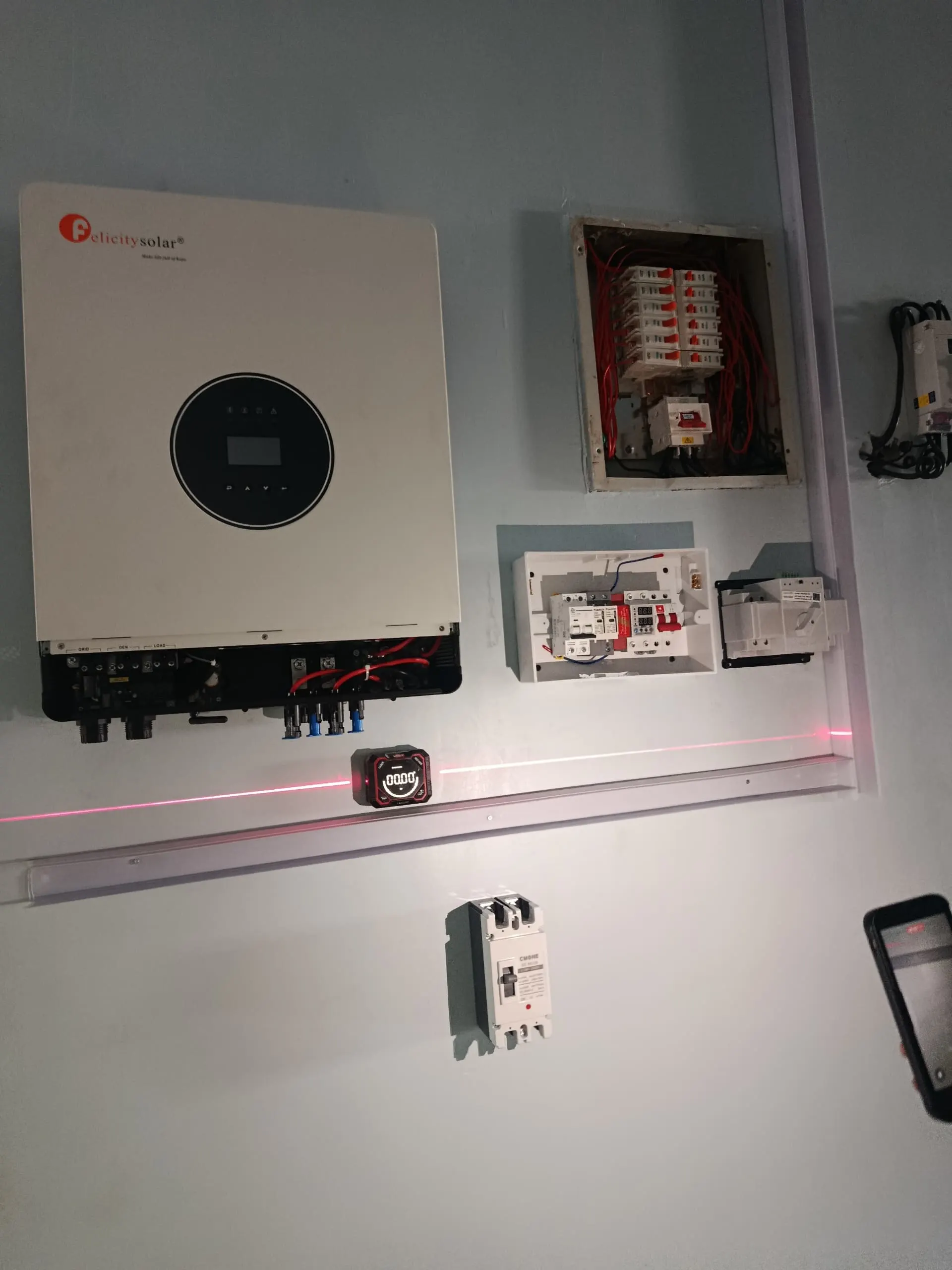 The inverter being set on the wall against a laser level line to get it square.