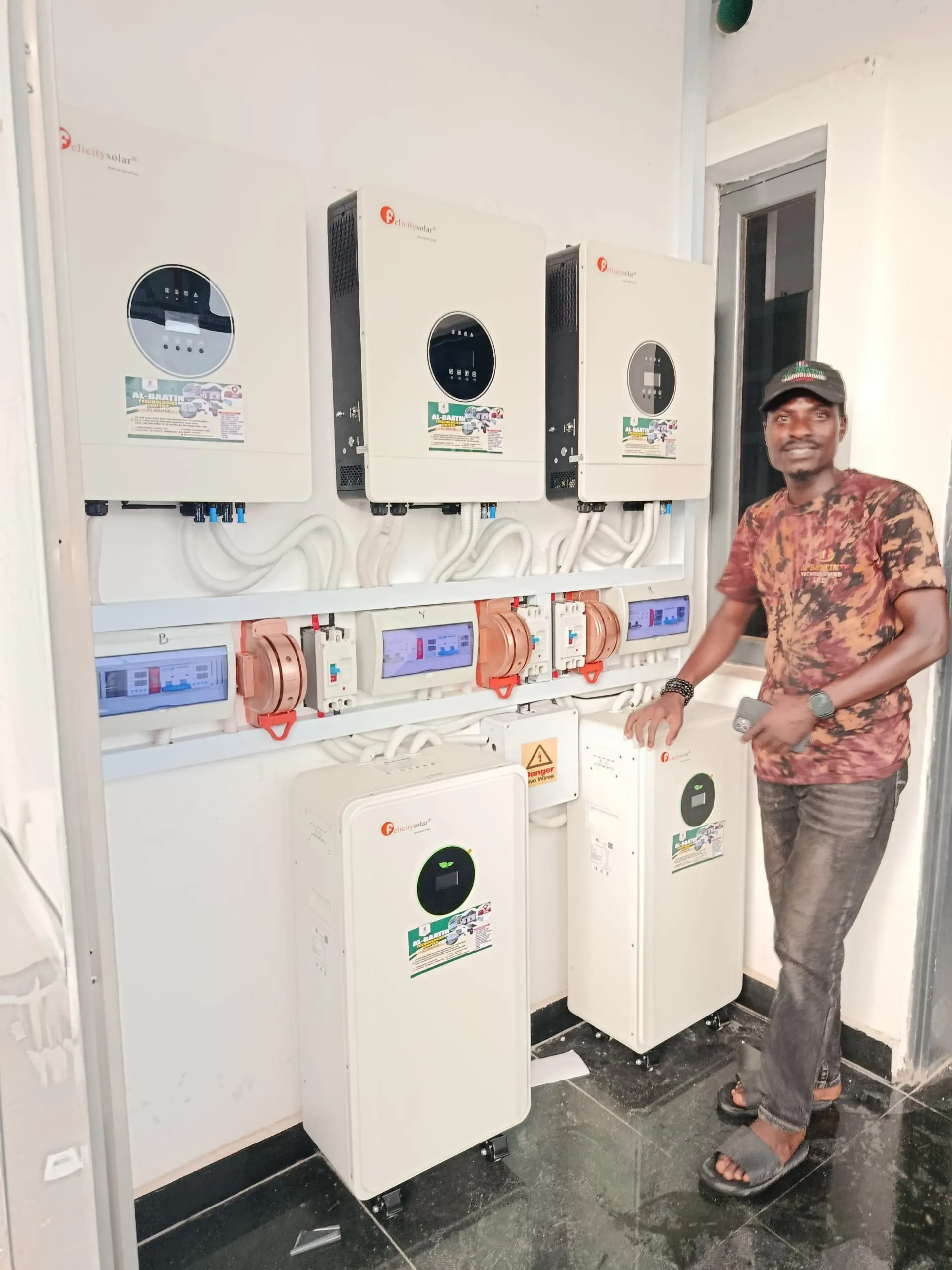 Al-Baatin standing beside the finished three-inverter wall.