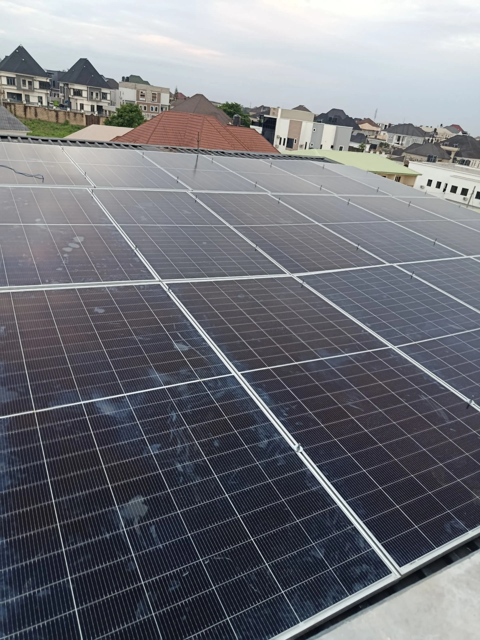 The completed run of solar panels installed across the metal roof.