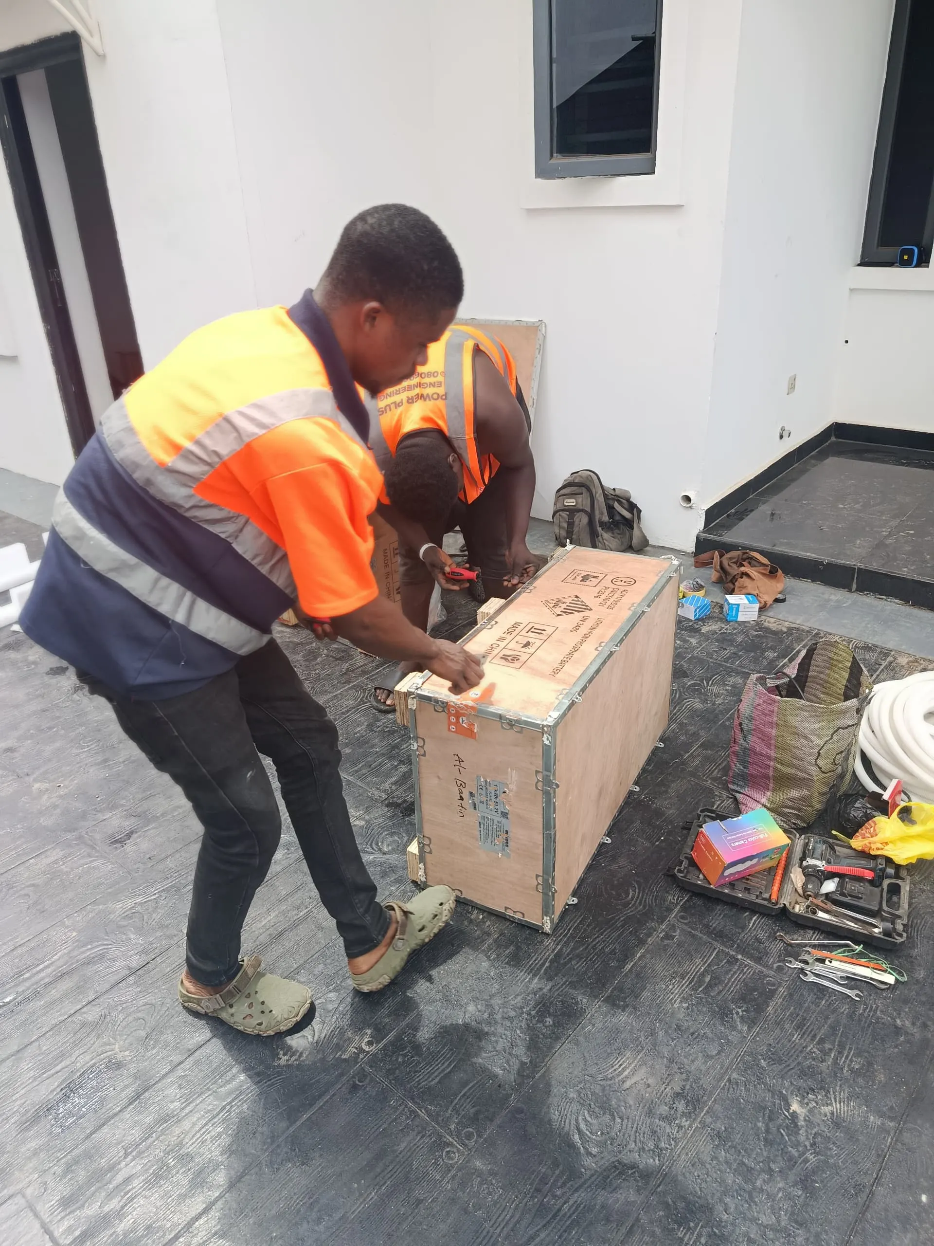 The crew unpacking a lithium battery from its shipping crate.