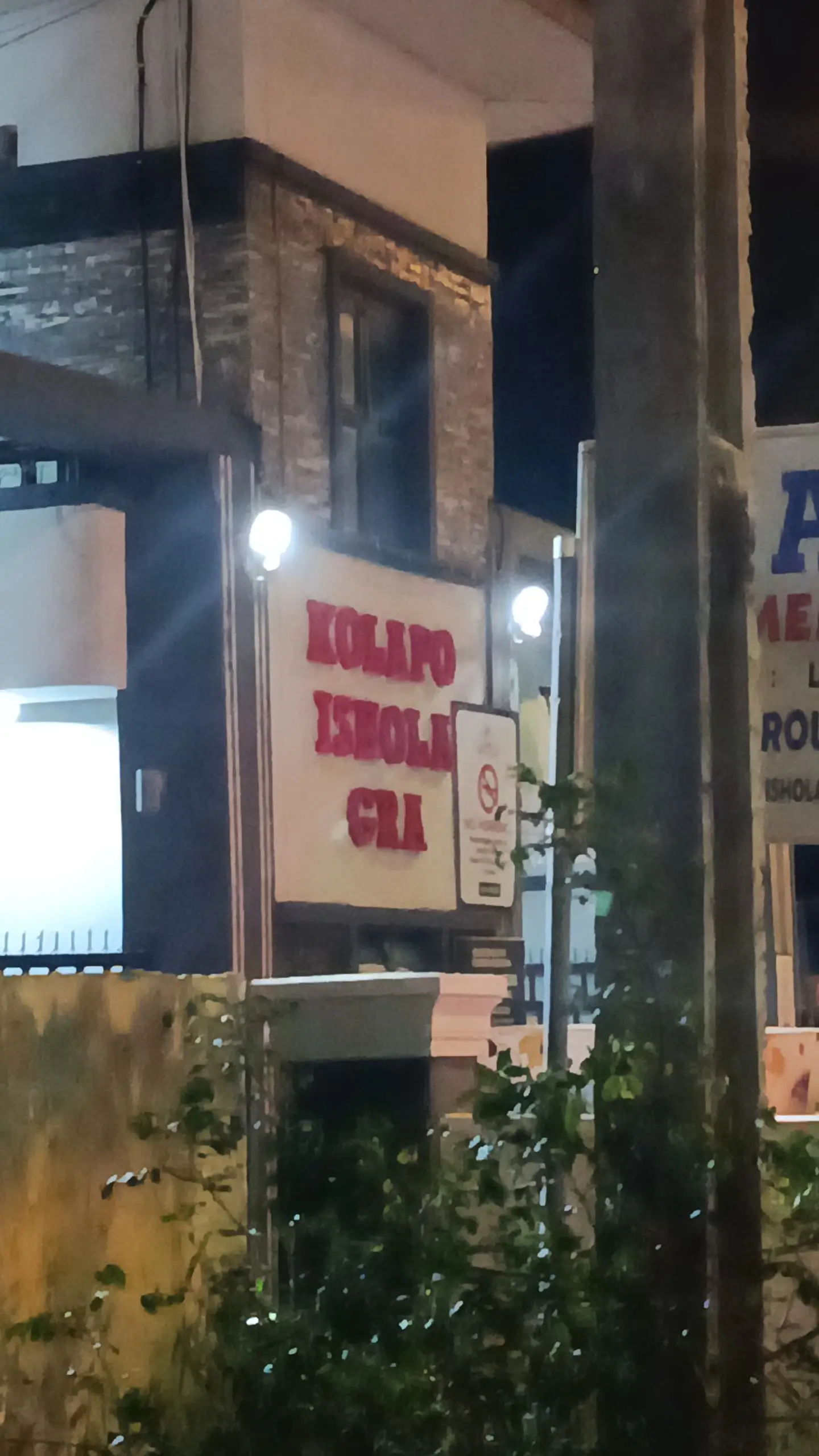 The Kolapo Ishola GRA estate signboard lit at night.