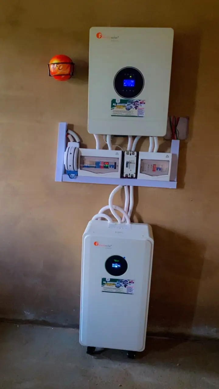 A 12kVA Felicity hybrid inverter mounted on the wall above a row of breaker boxes, with a floor-standing lithium battery below.