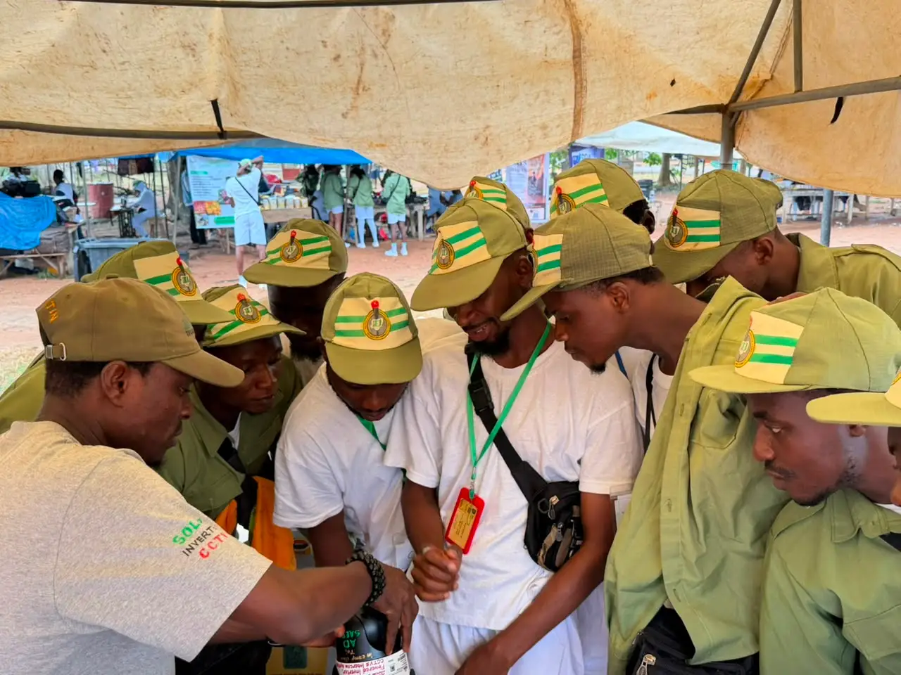 Corps members gathered around equipment during a hands-on practical session.